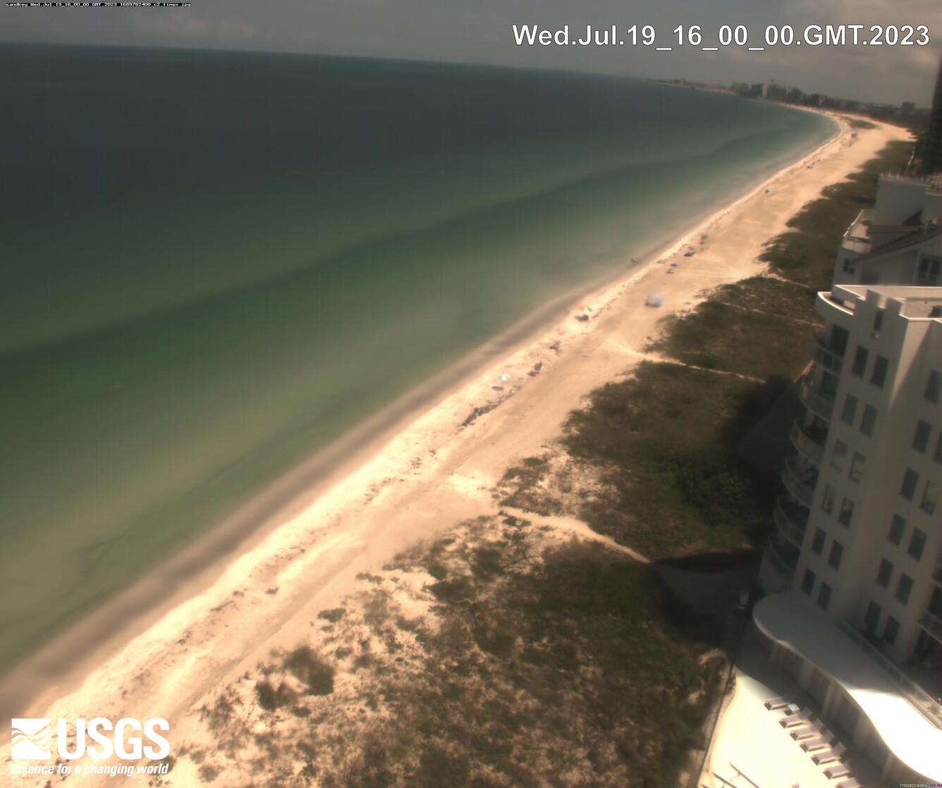 A time-averaged image of a beach with a large hotel on the right and the Gulf of Mexico to the left.