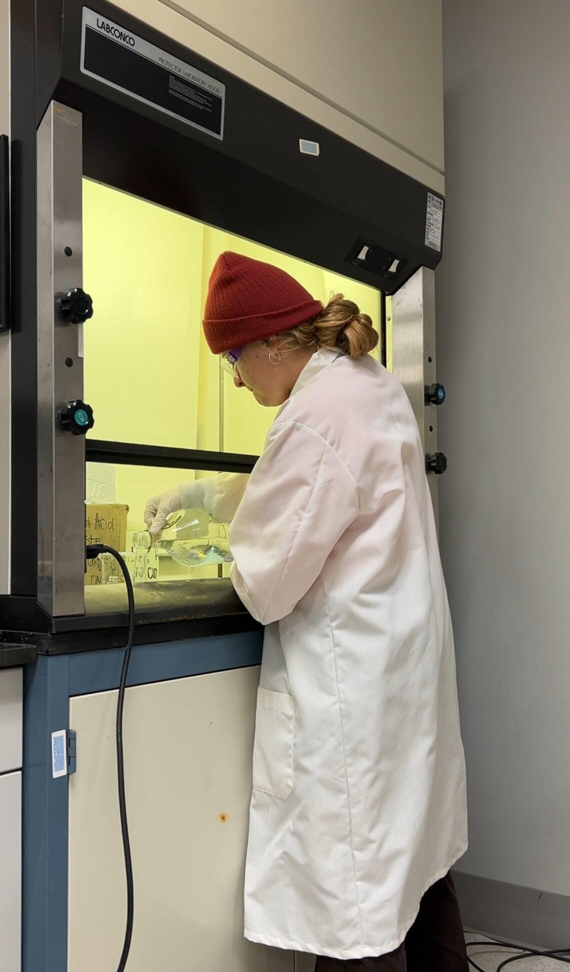 Scientist conducting experiment in fume hood in water quality laboratory