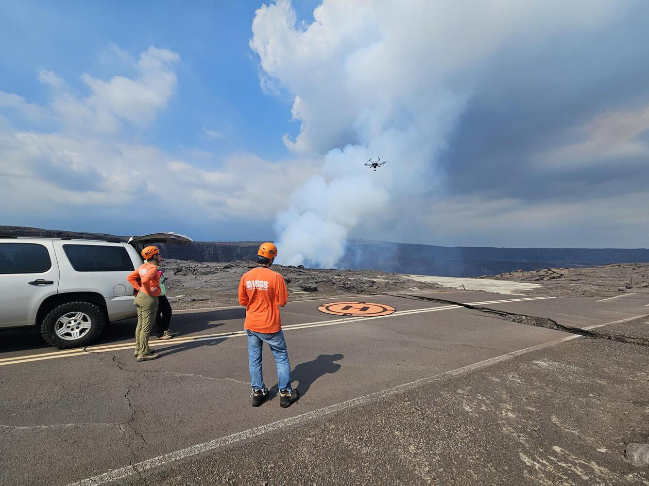 Color photograph of scientists near car operating UAS