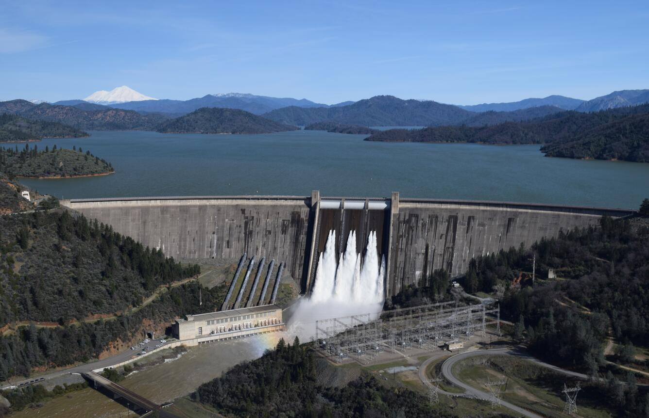 Aerial front view of Shasta Dam with Shasta Lake in the background