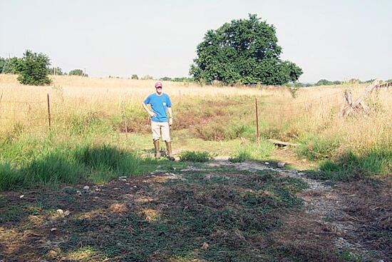 A scientist standing in a completely dry creek bed