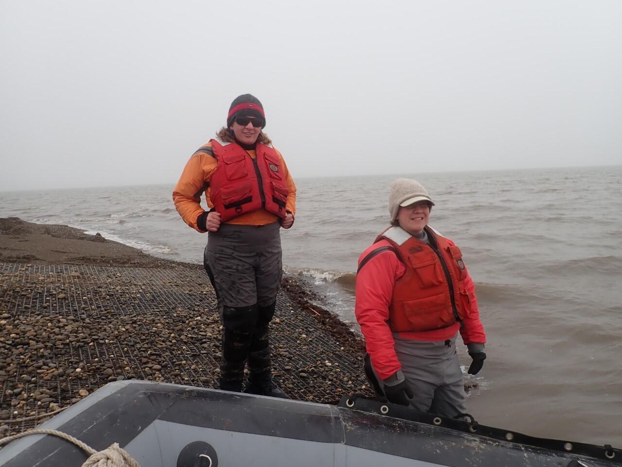 USGS scientists Vanessa von Biela and Sarah Laske standing on shore near Prudhoe Bay, Alaska