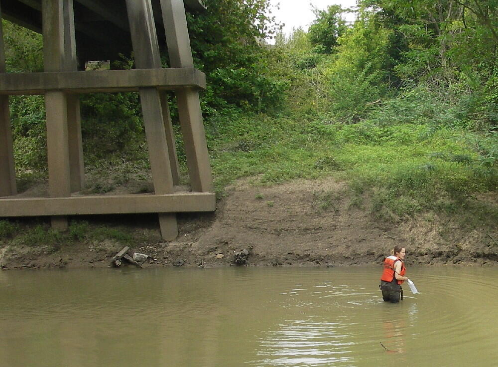 USGS Scientist standing in thigh deep water collecting a water-quality sample