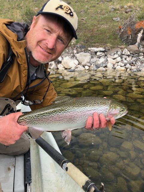 male scientist, wearing a hat, holding a fish