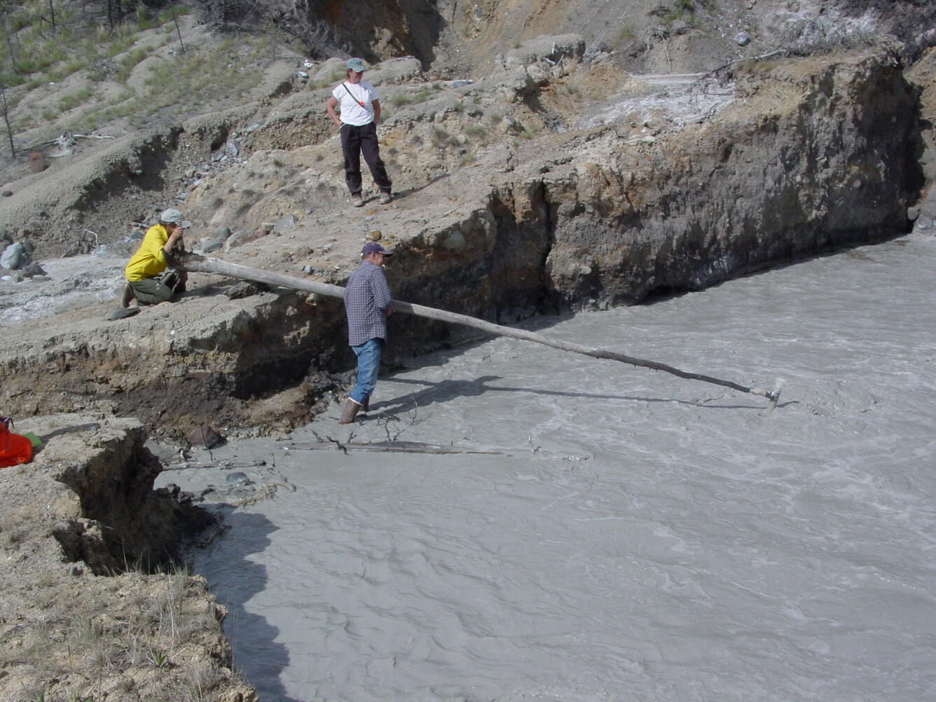 USGS National Research Program scientists collecting gas samples from an Alaskan mud volcano.