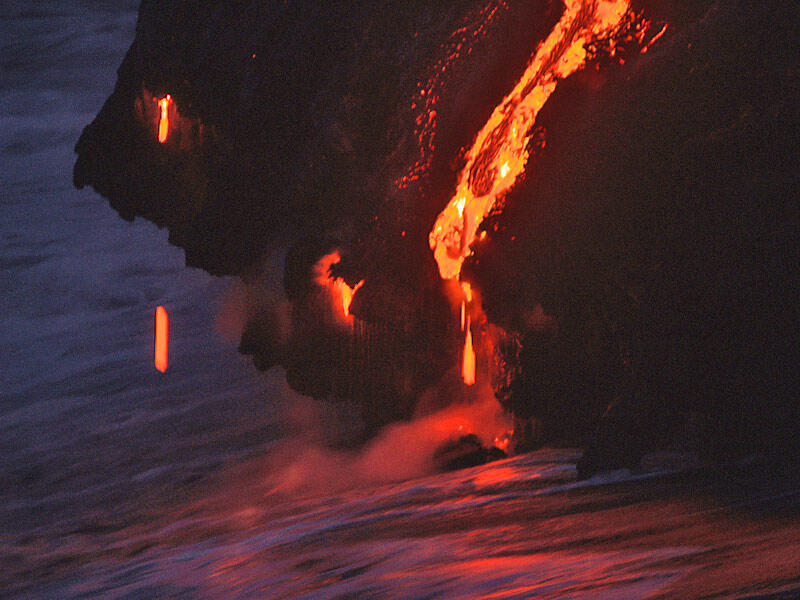 This is a photo of lava falling, dripping, and running into water in area of former point on western delta.