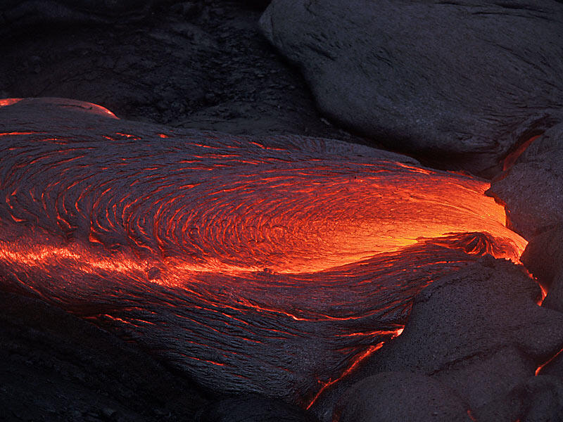 This is a photo of lava welling up from under crust and flowing down a gentle slope.