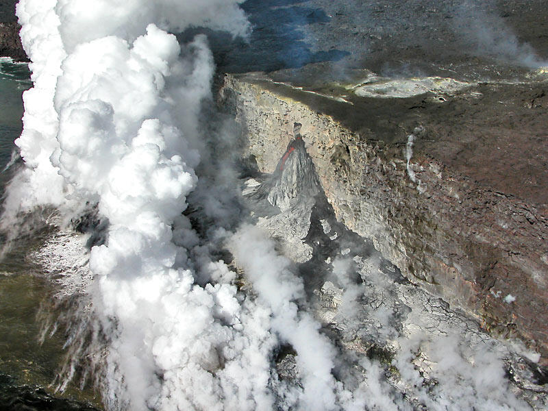 This is a photo of a new lava delta and feeding stream of lava emerging from tube high on cliff.