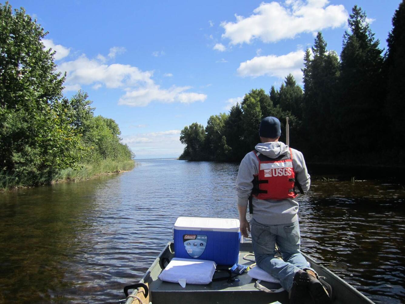 USGS employee on boat in river heading out 