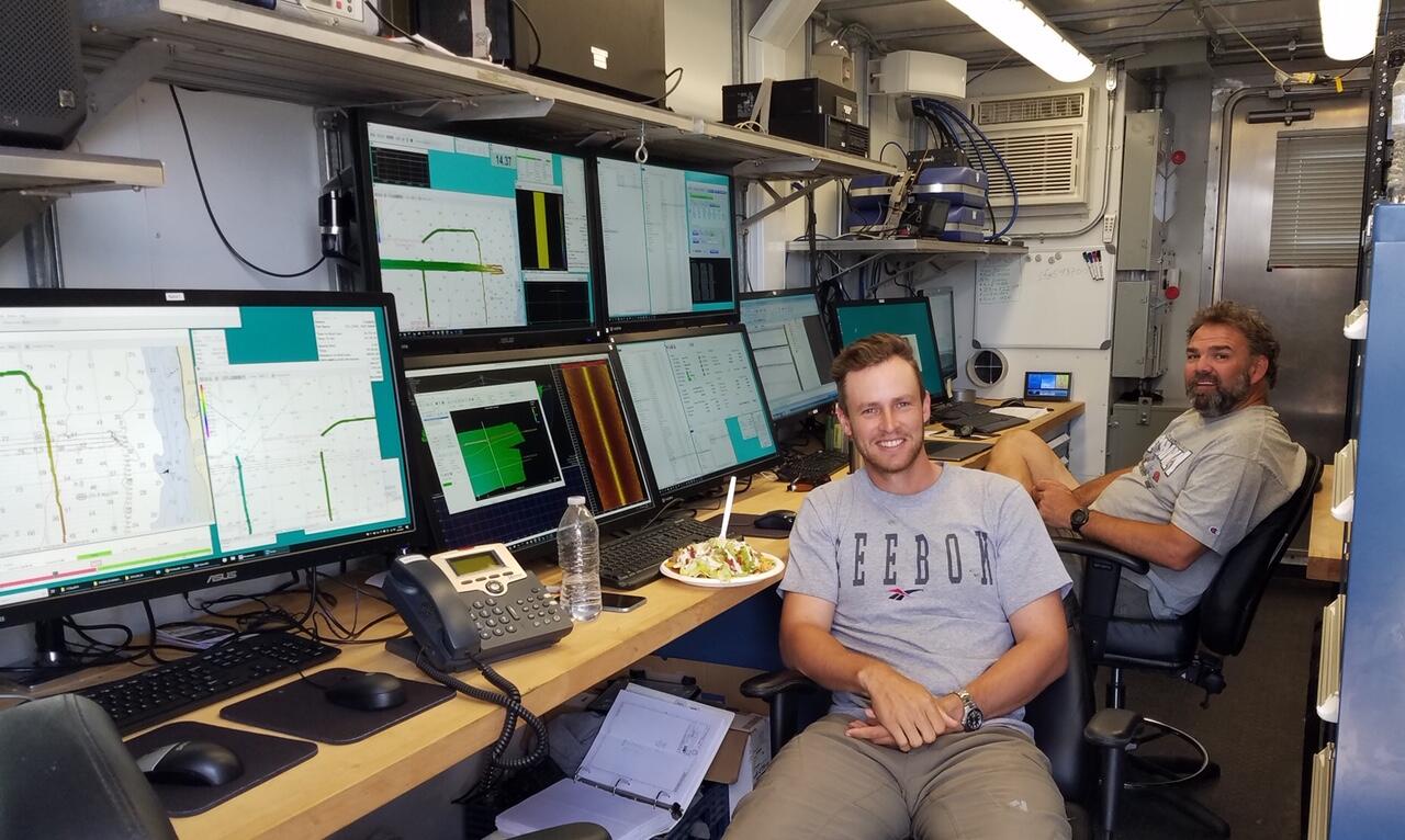 People watching data on multiple computers while eating dinner