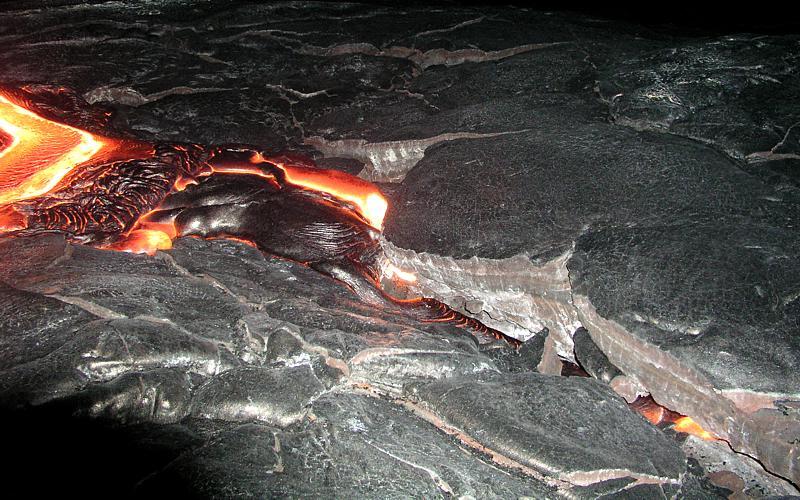 Lava flowing from the surface into preexisting cracks and cavities