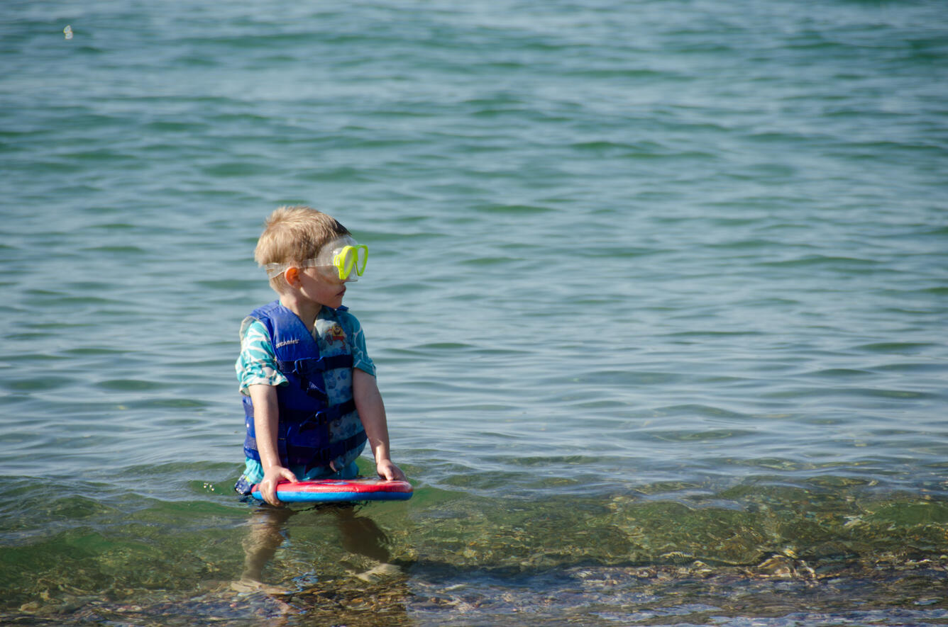 Photo of a boy playing in the water on a Wisconsin beach.