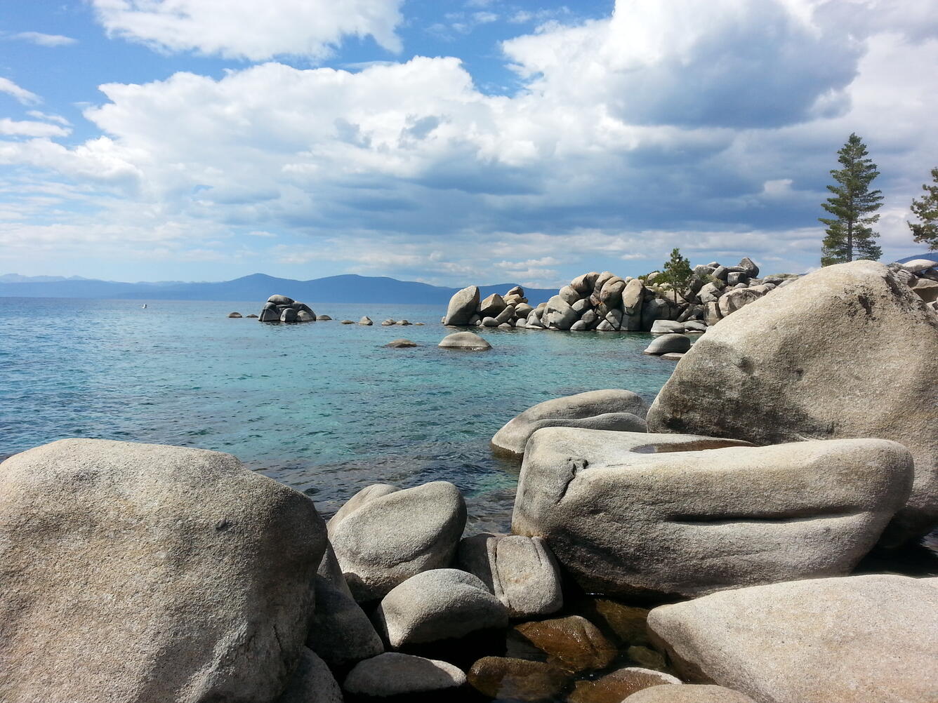lake basin with rocks in foreground and trees in the right