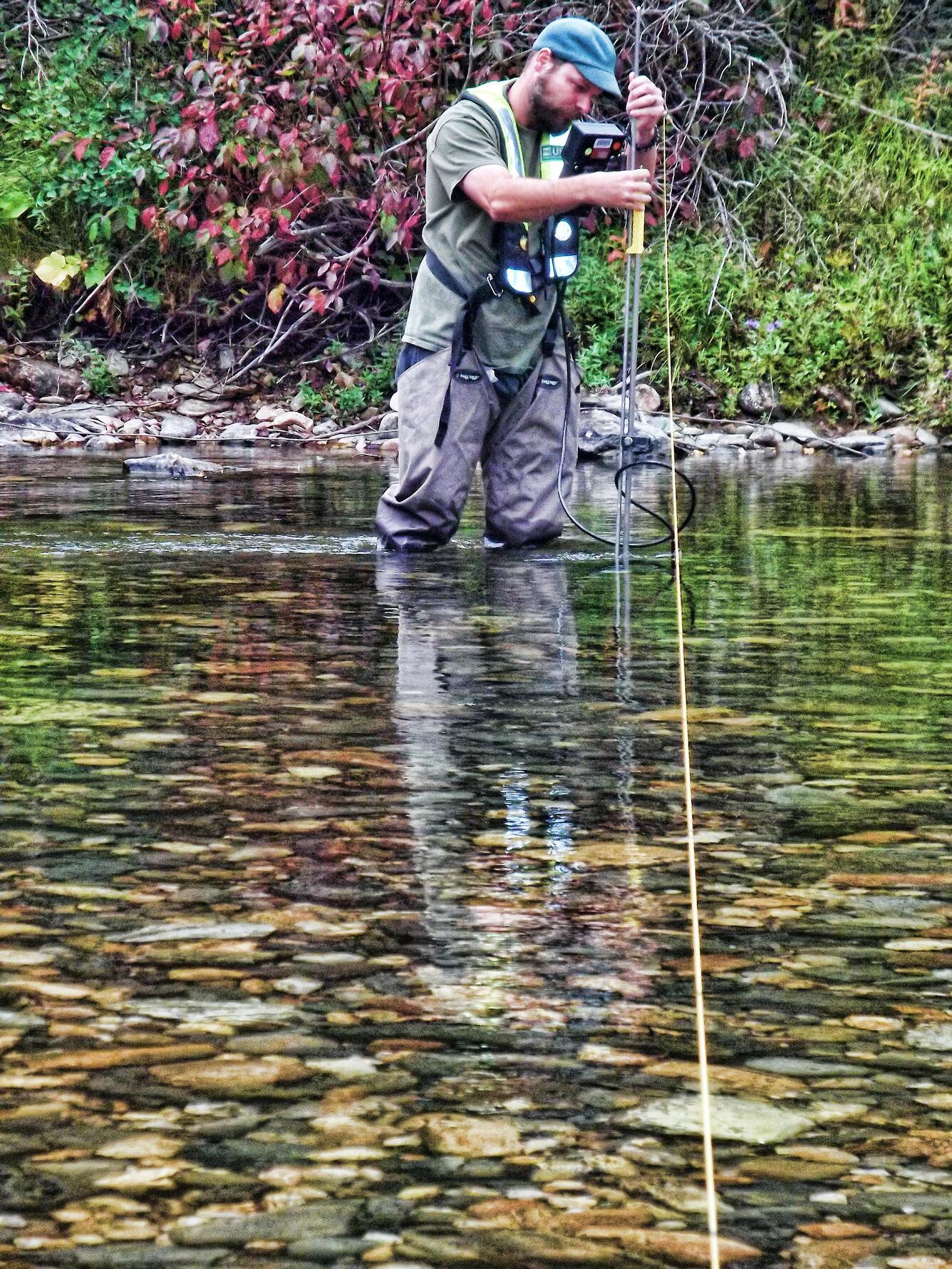 A hydrologic technician from the USGS Idaho Water Science Center measures streamflow in the St. Joe River at Red Ives Ranger Sta