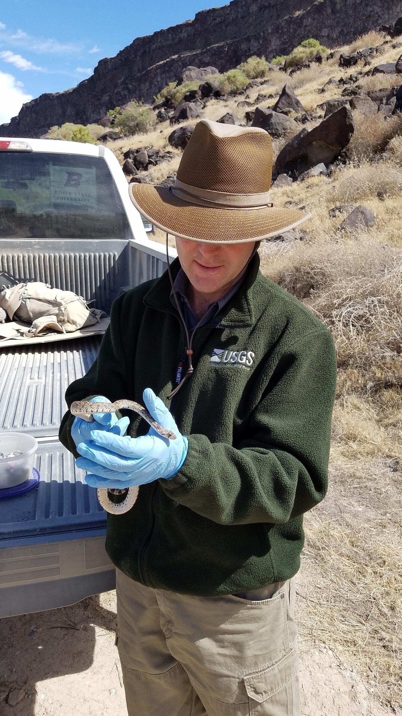 USGS employee holds a snake