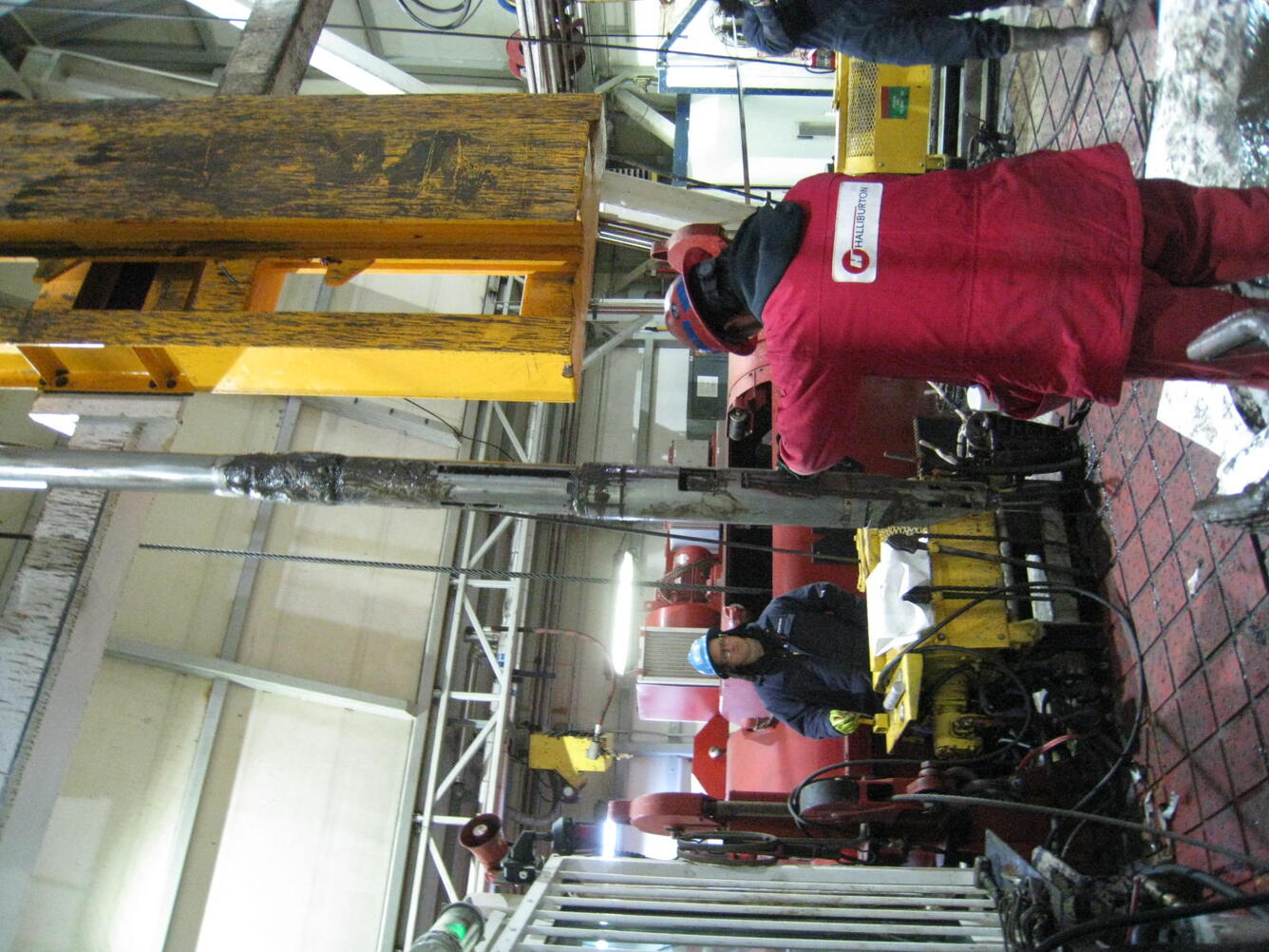 Image shows technicians in safety equipment working with the well piping.