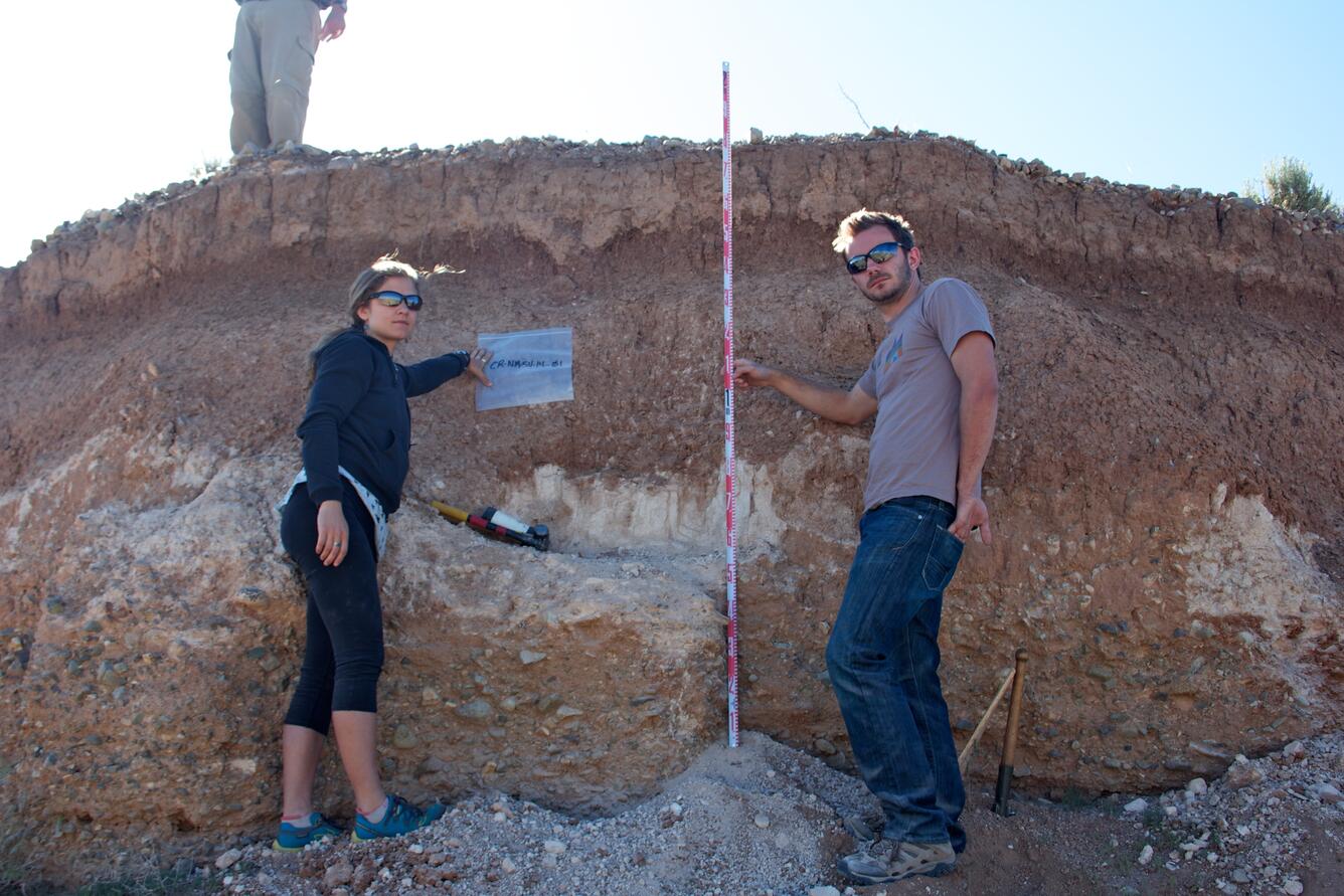 Workers standing in front of sediment deposit