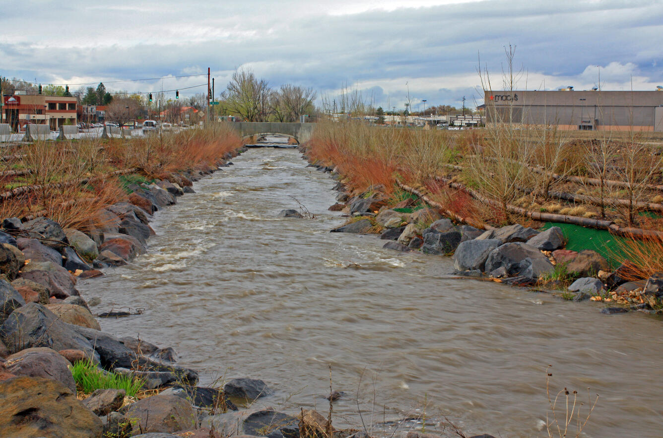 Creek; traffic bridge and shopping centers in the background