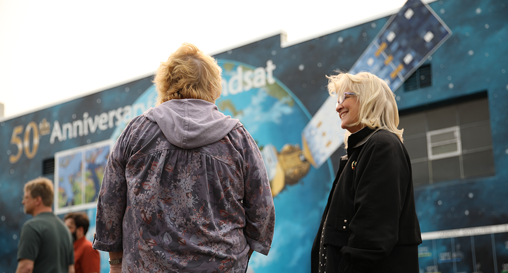 Color photo of visitors to the Landsat Mural dedication in Lompoc, CA