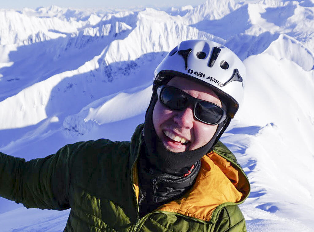 Adrian Bender is geared up with climbing gear to prepare to ski from the top of a mountain in southcentral Alaska