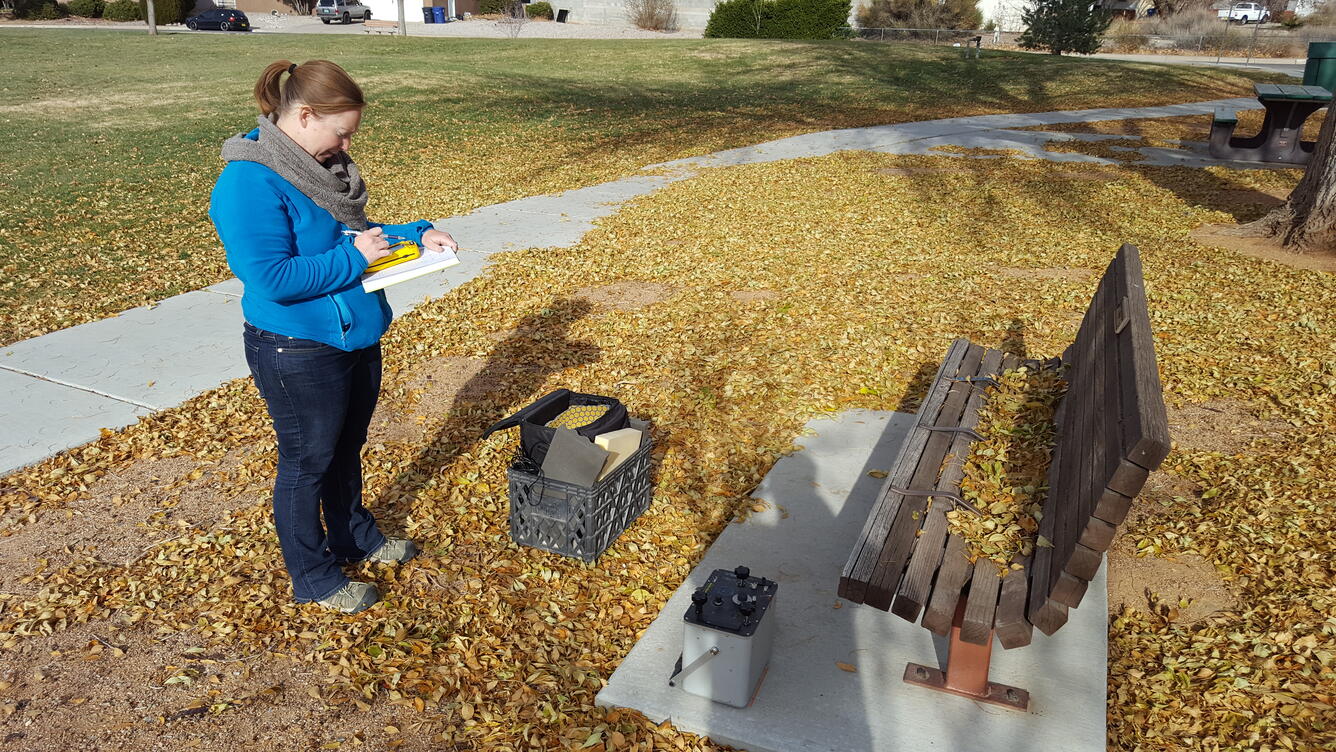 Photograph showing a USGS hydrologist with a relative-gravity meter at a city park in Albuquerque, NM