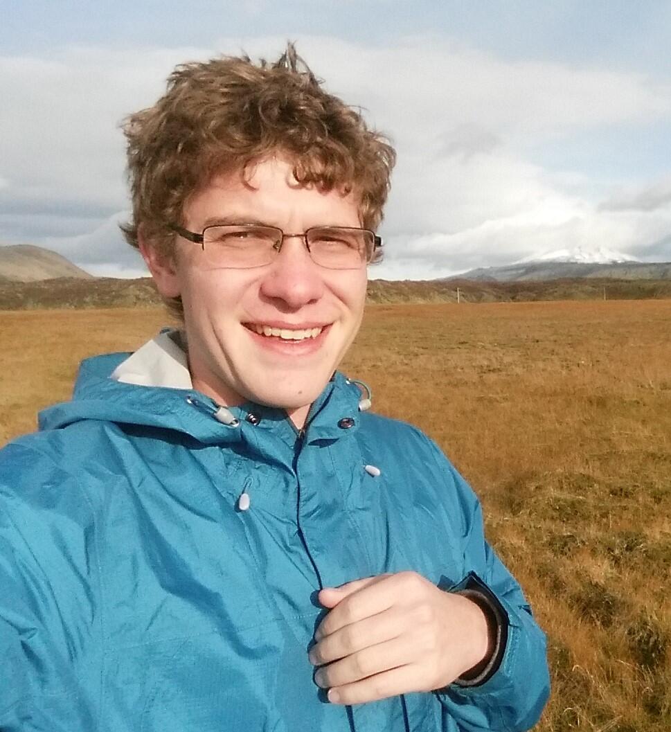 Anthony Pivarunas on basalt flow with volcano in background