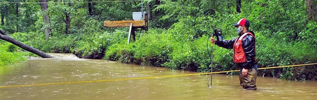 Image shows USGS field crew conducting measurements on flooding streams