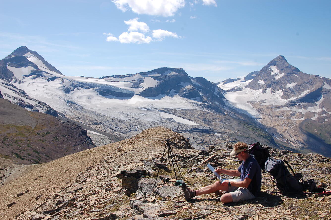 A person sets up a repeat photograph of Blackfoot Glacier in Glacier National Park.