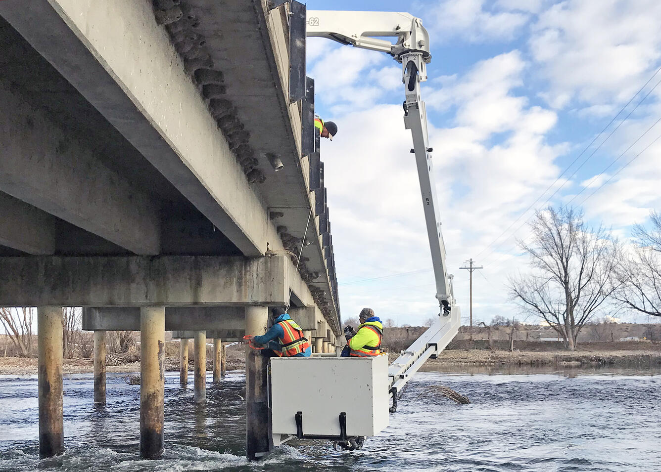 USGS hydrologic technicians install an echosounder on the bridge over the Payette River near Letha, Idaho