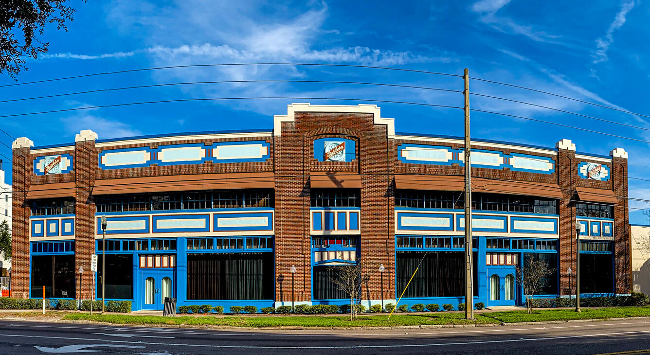 A brick building with blue trimmed windows and a blue sky