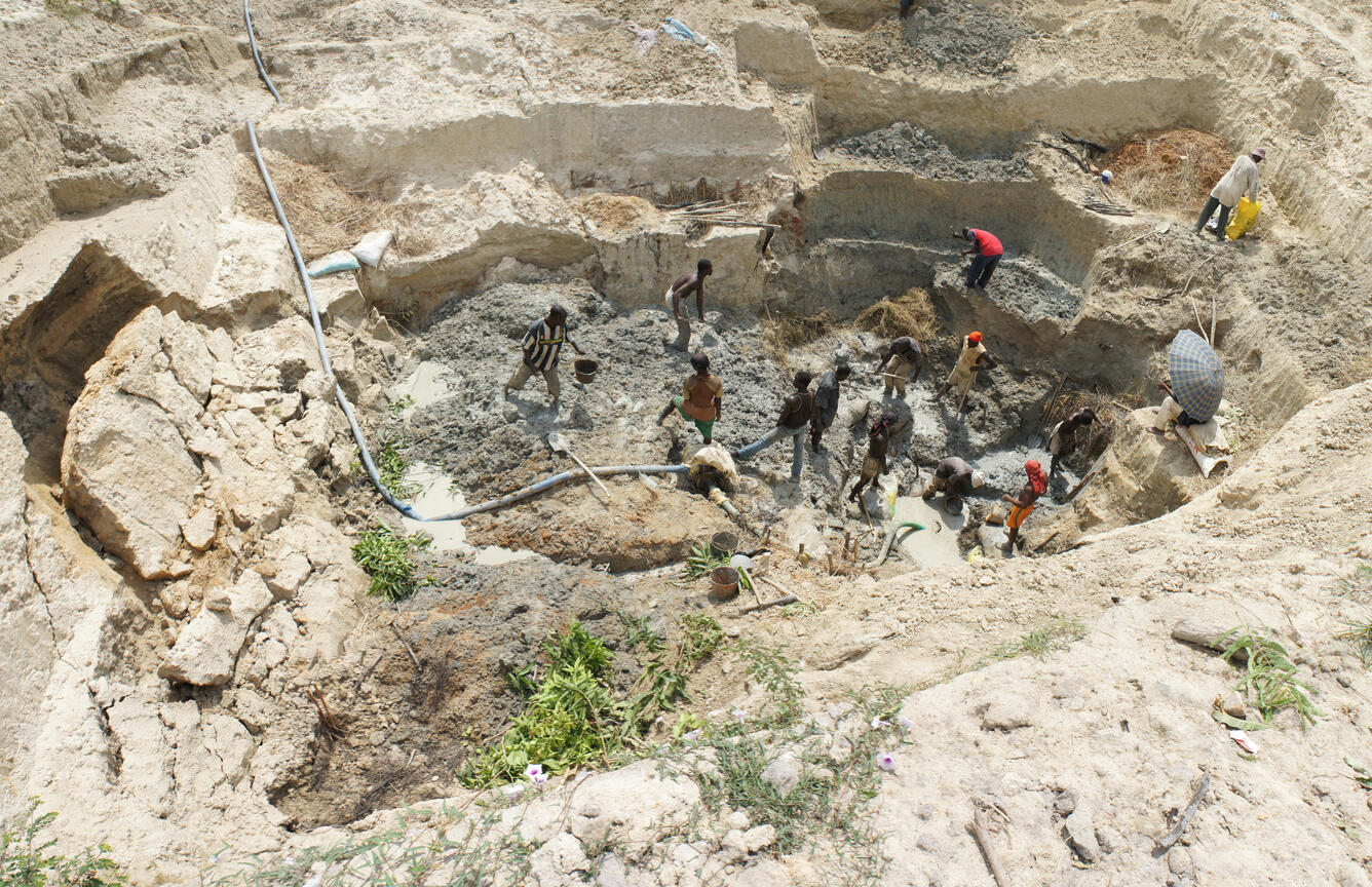 Artisanal miners digging a typical mining pit using simple tools such as shovels, buckets and water pumps in Côte d’Ivoire. 