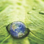 Reflection of Earth in water drop on a leaf