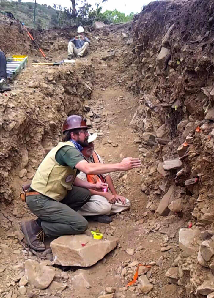 Geologists in a trench analyizing the stratigraphy