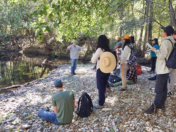 Scientist addresses students on the bank of the Carmel River