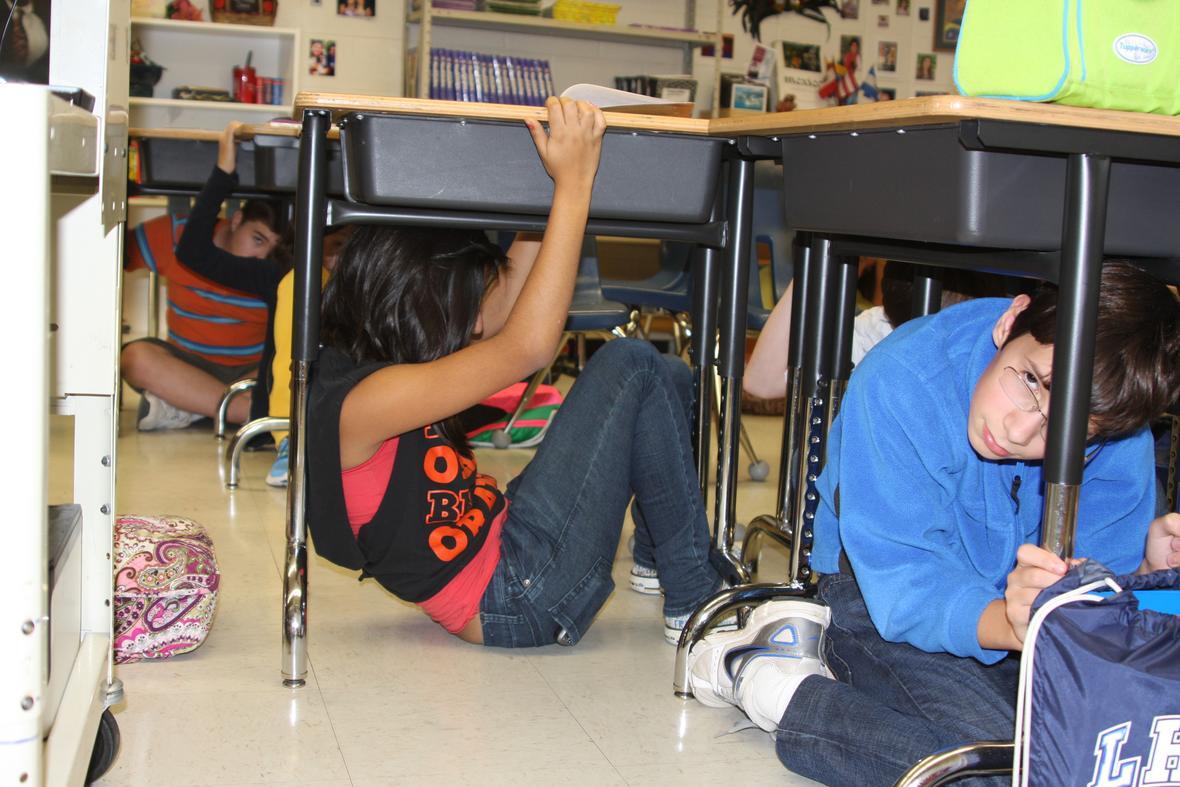 Kids under desks in a classroom