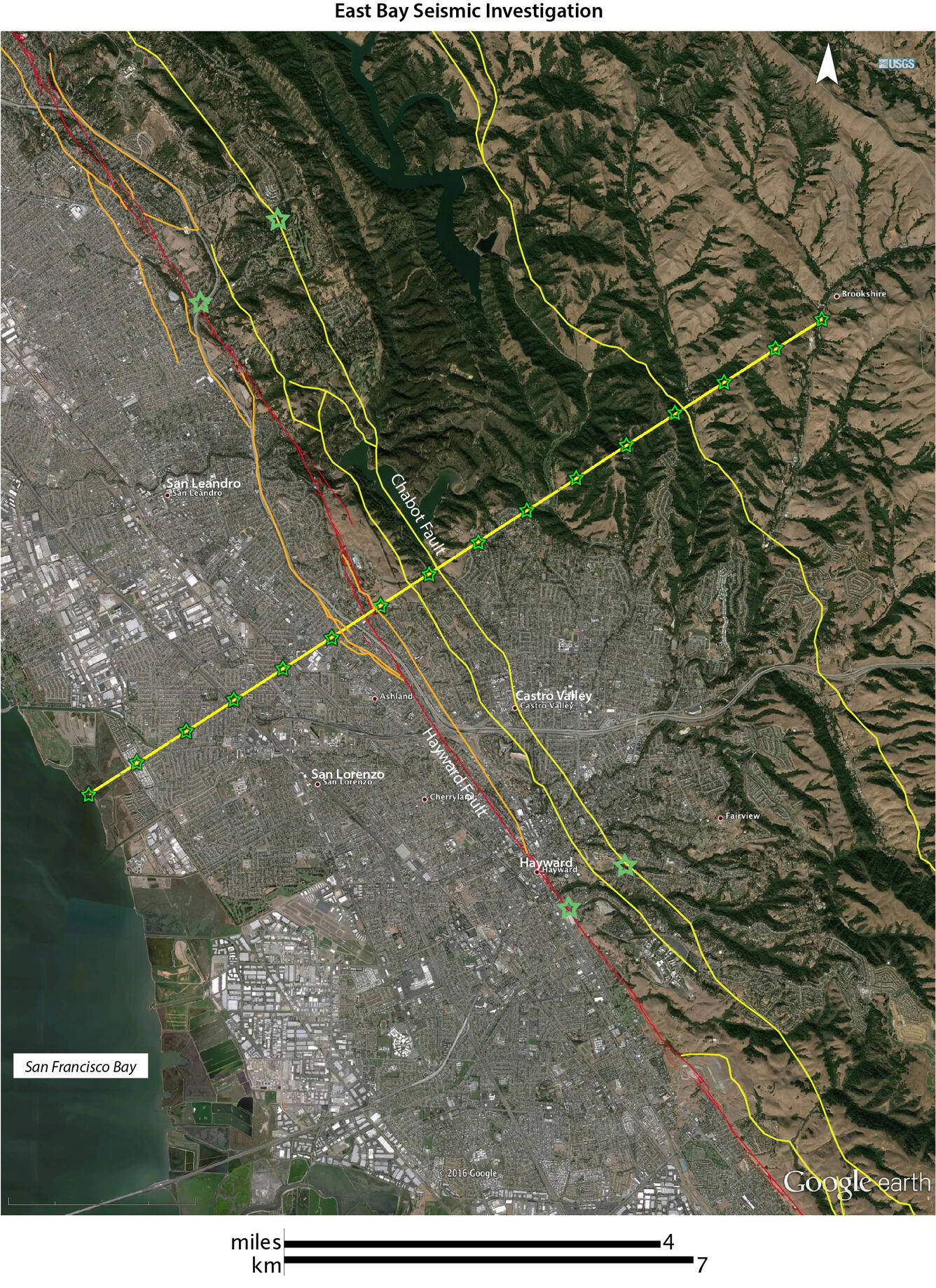 Satellite image of urban area, with green hills to the northeast. Area is criss-crossed with various colored lines.