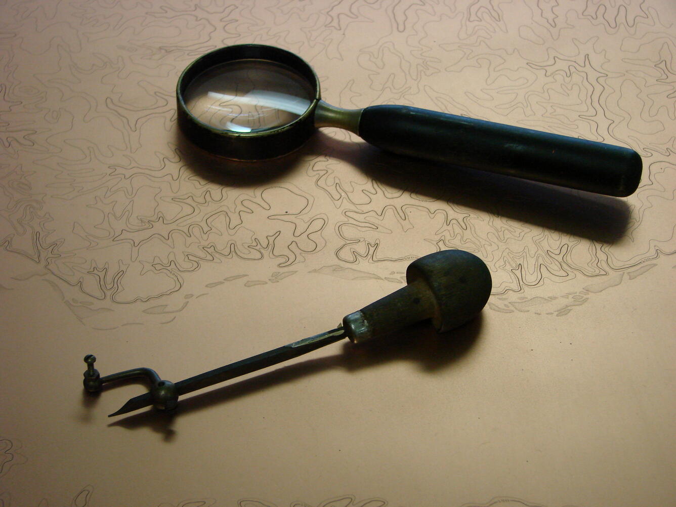 Hand lens and burin; two of the tools used for engraving copper plates.
