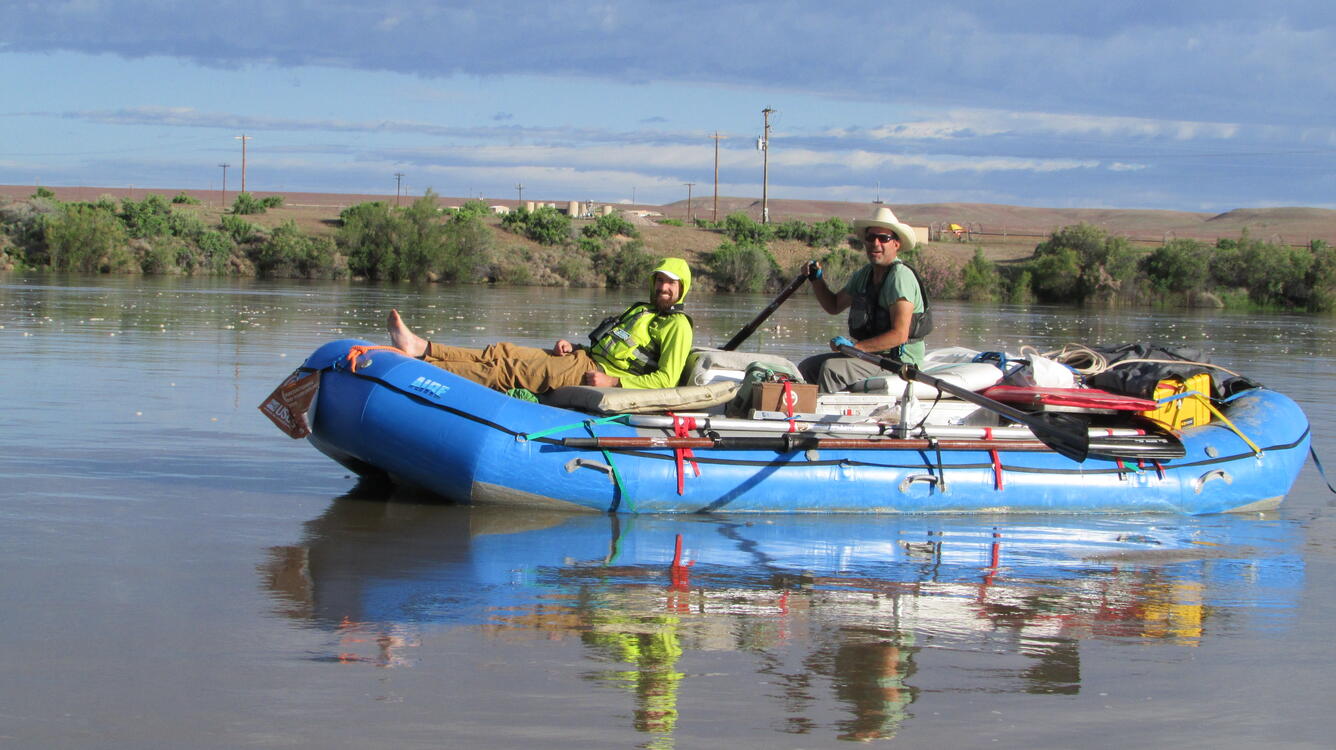 Two guys in raft smiling at camera.