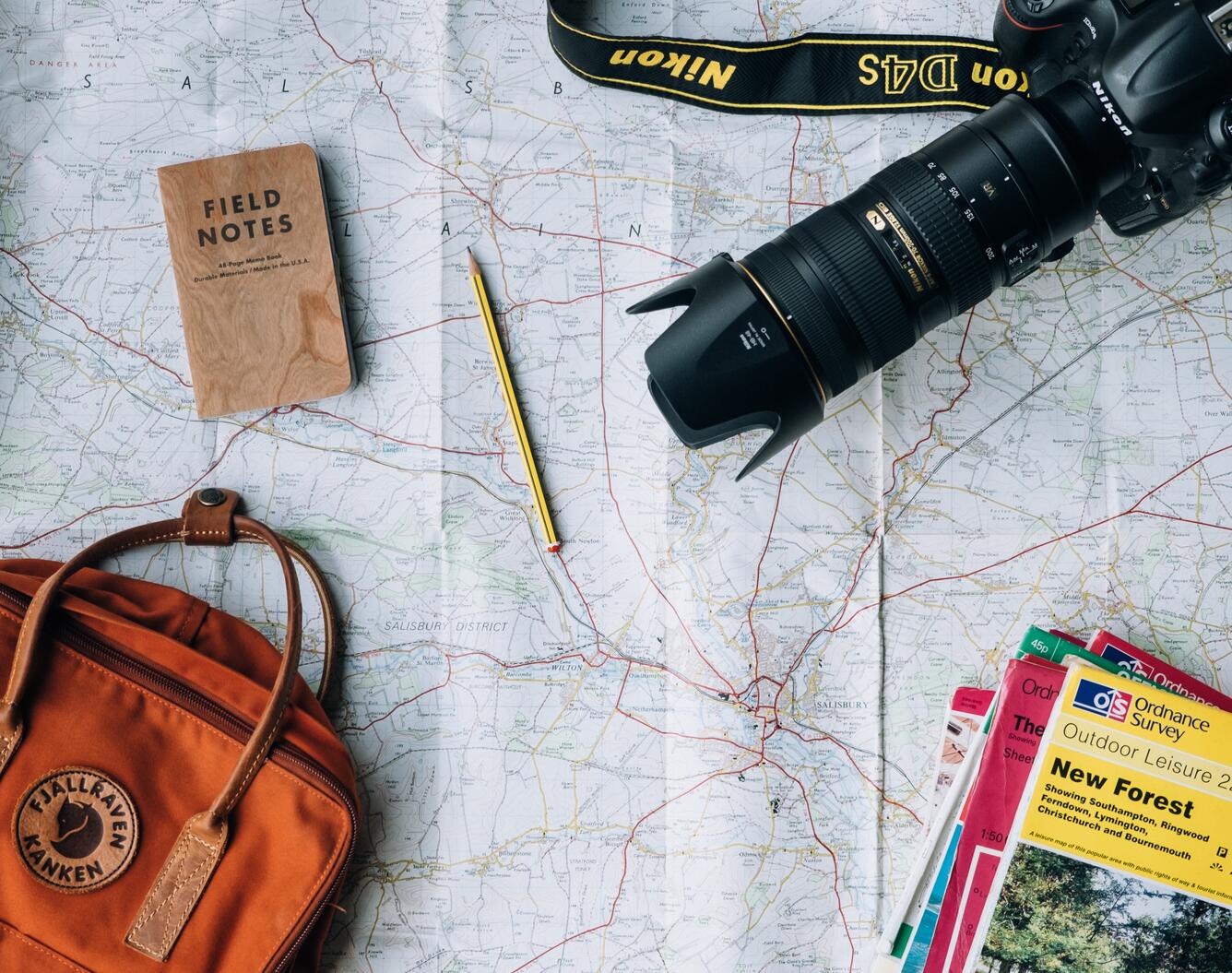 Travel themed picture with maps field notes pencil camera 