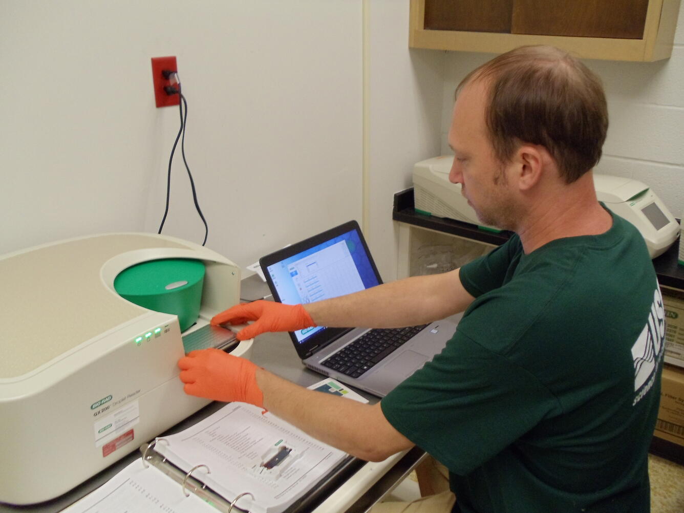 Dr. Aaron Aunins loading a plate of Polymerase Chain Reaction product