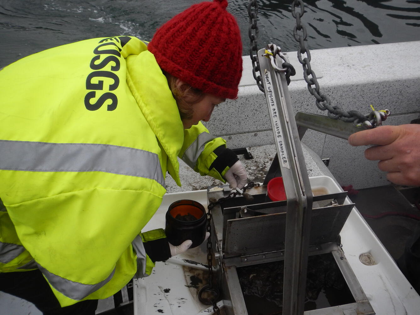 Photo of hydrologist Kathy Conn collecting sediment from Puget Sound, Washington