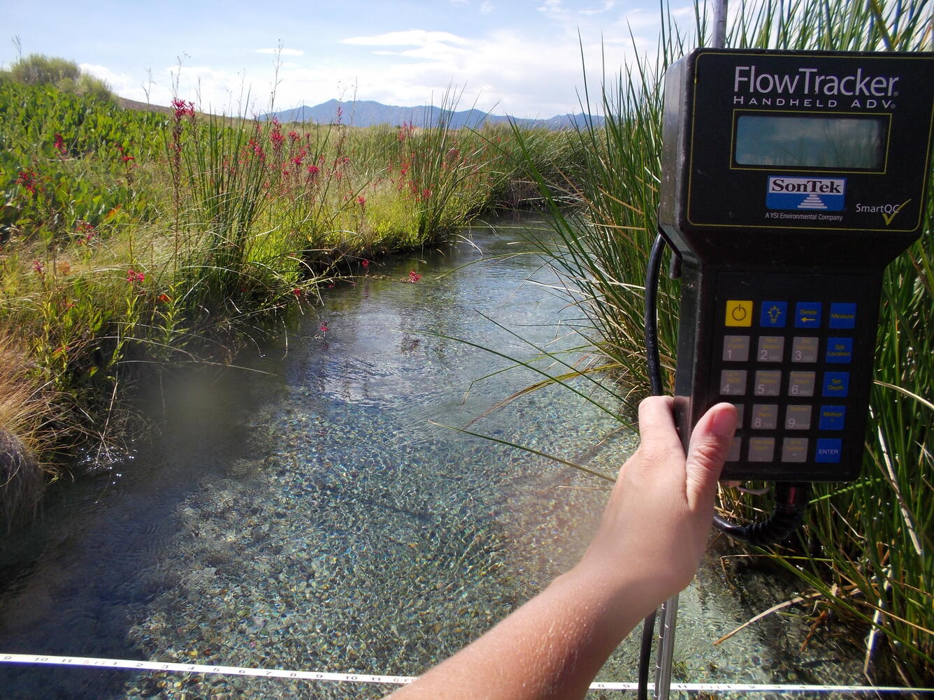 USGS scientist taking a discharge measurement at Hot Creek near Sunnyside, NV