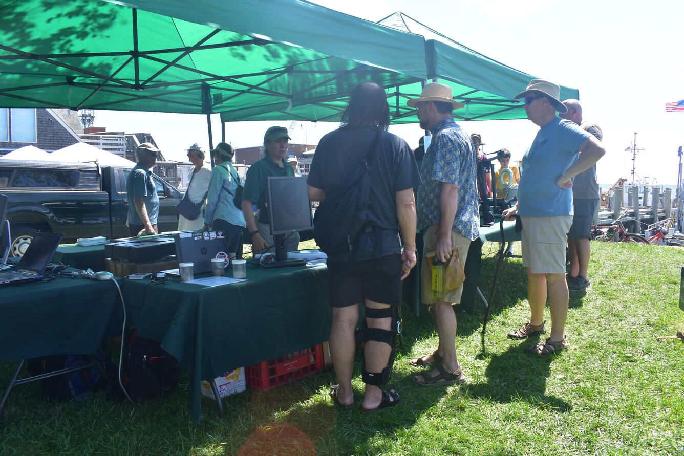 Woman showing instrumentation to visitors at an outreach event