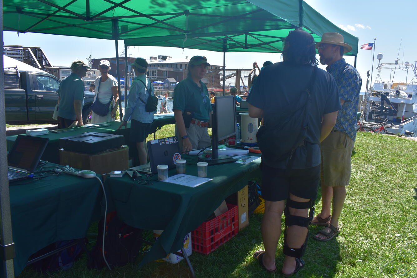 Woman showing instrumentation to visitors at an outreach event