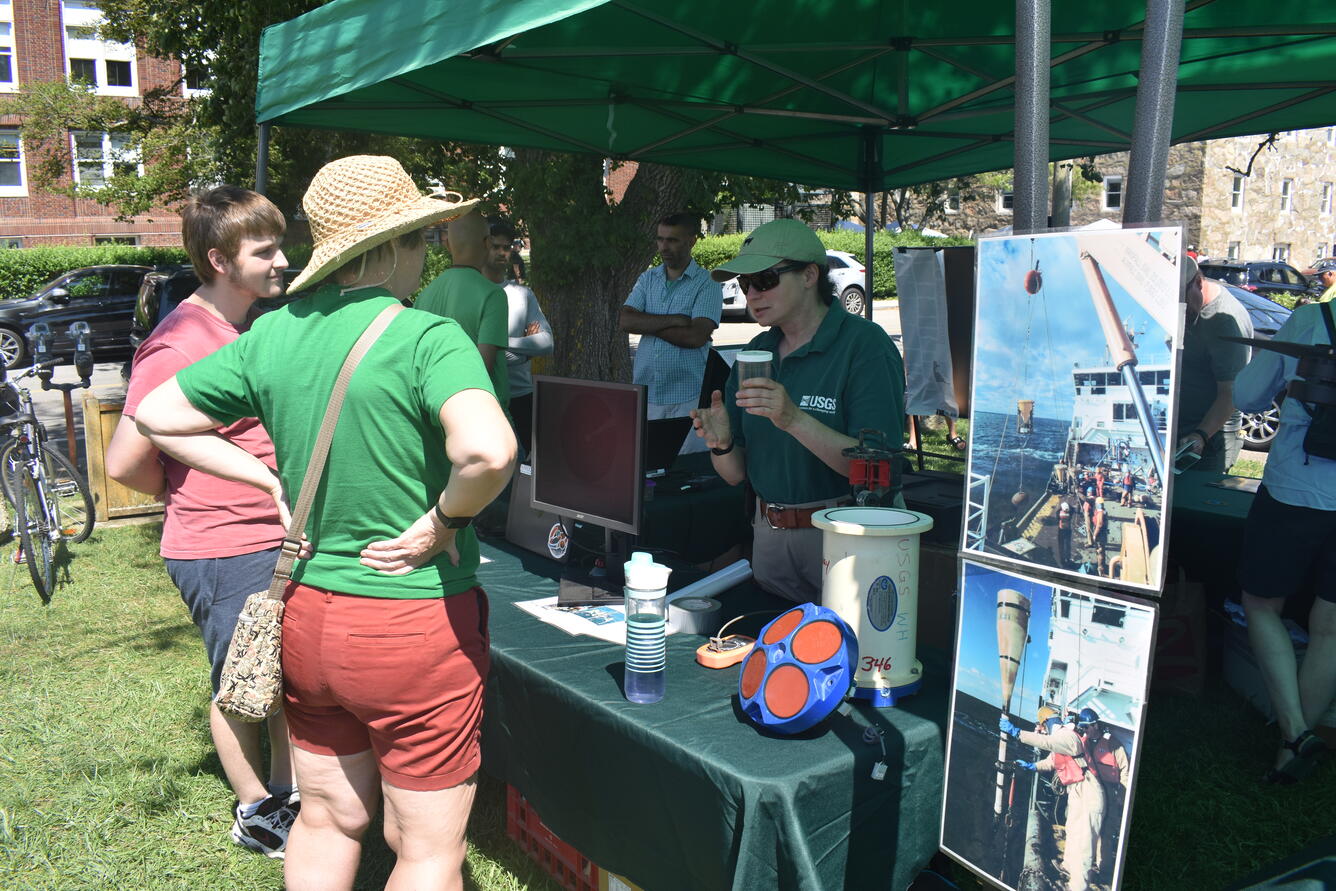 Woman showing instrumentation to visitors at an outreach event