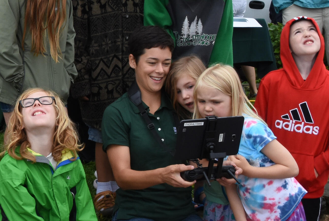 Image of Emily Sturdivant flying UAS with curious onlookers