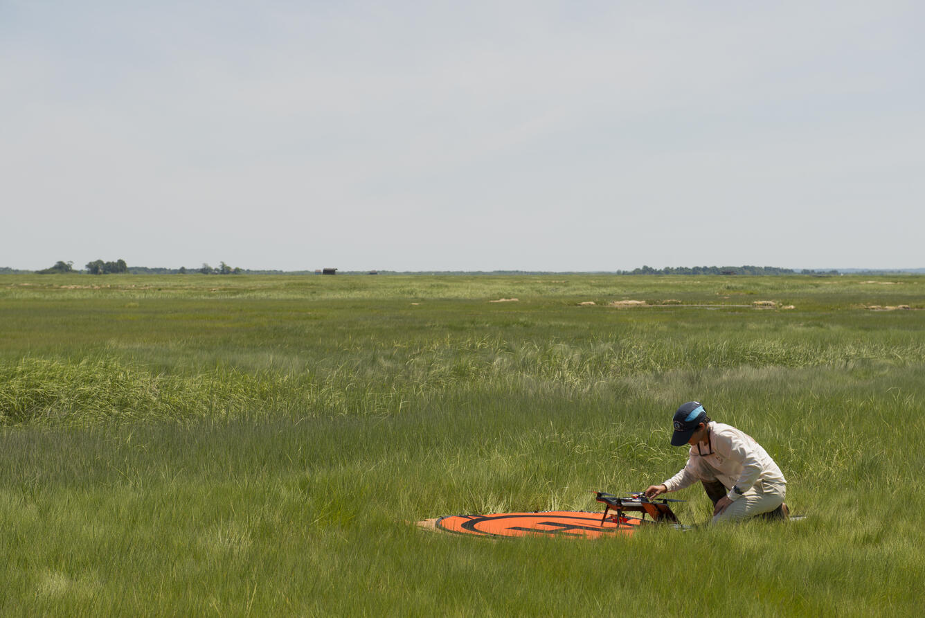 woman in the grass working with a drone