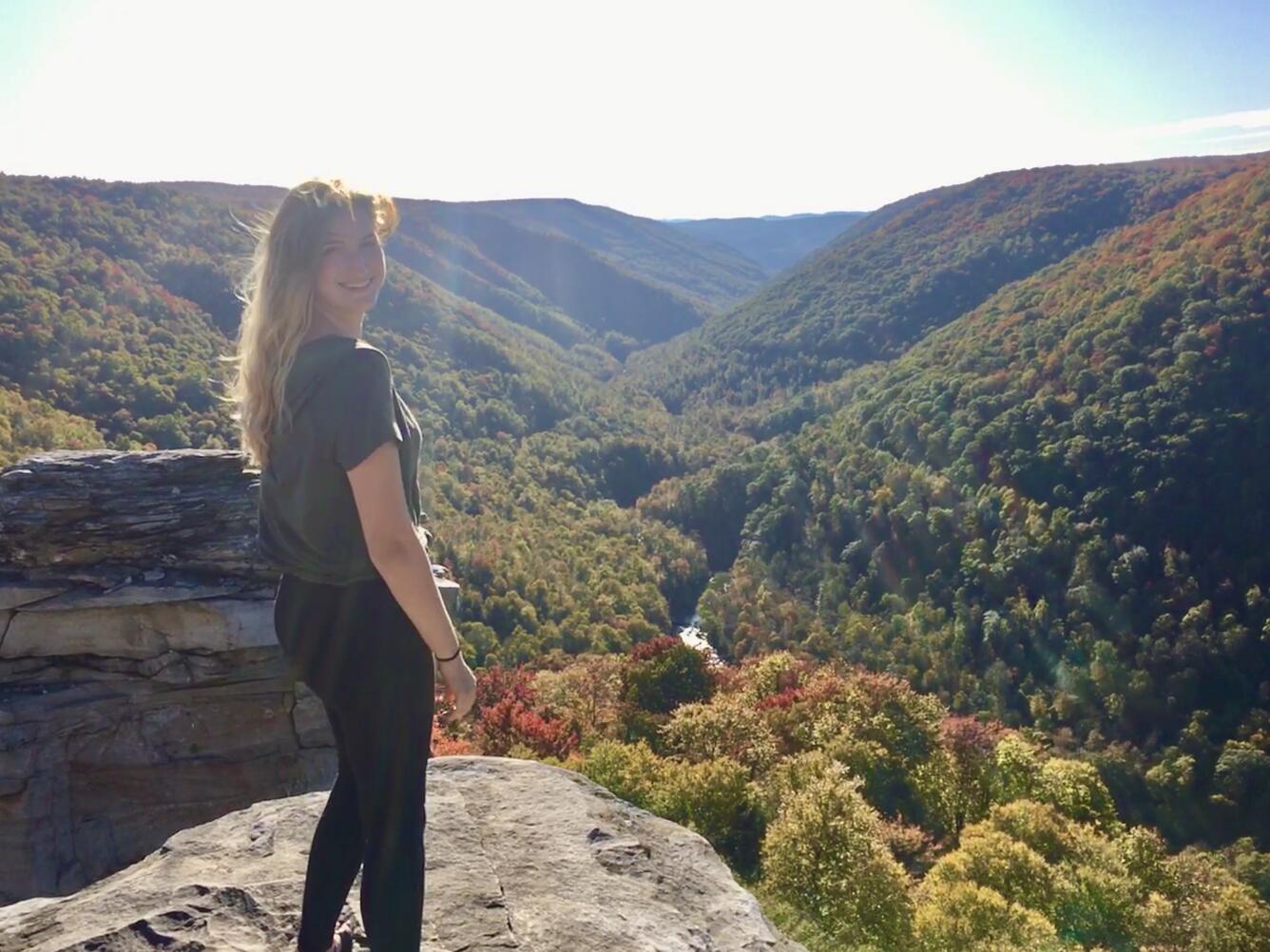 Photo of Hydrologic Technician Caitlyn Dugan, overlooking a WV stream