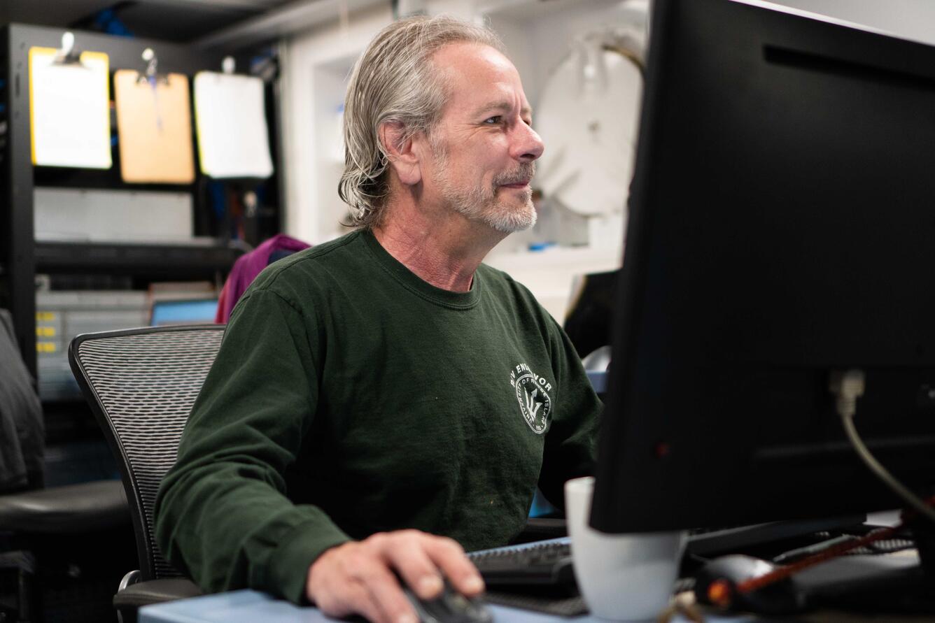 Image shows a man at a computer desk