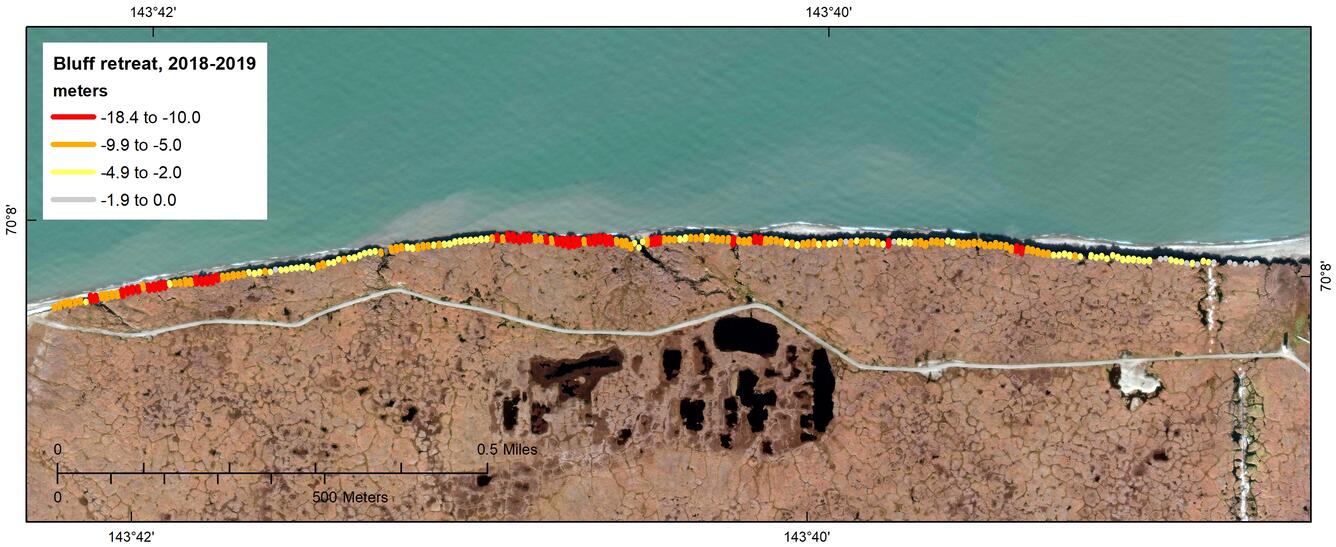 Aerial view of a coastal area with dots of different colors that correspond to varying amounts of bluff retreat.